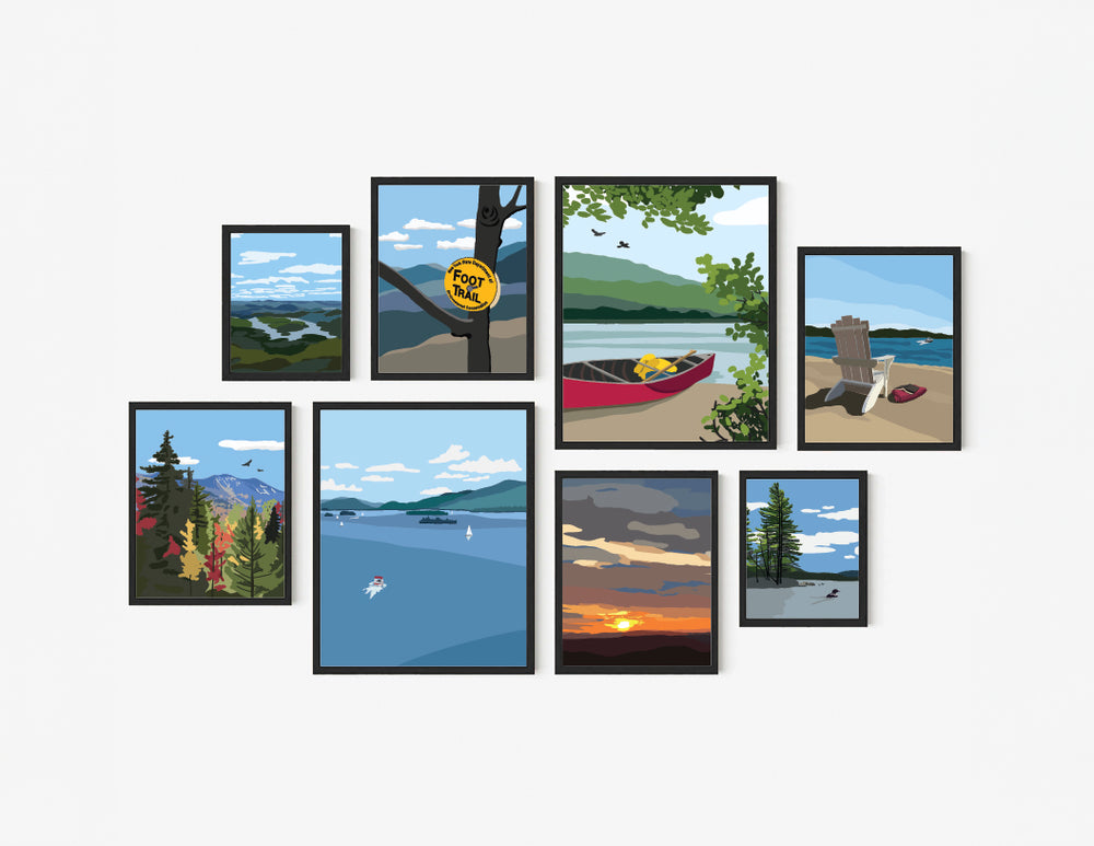 Set of eight framed illustrated Adirondack themed art prints featuring various outdoor scenes including a canoe on a lake, an Adirondack chair on a beach, a high peaks image in fall, lake placid from the top of whiteface, a foot trail marker on a tree, a sunset and two lake prints, one with a loon and one of lake George.