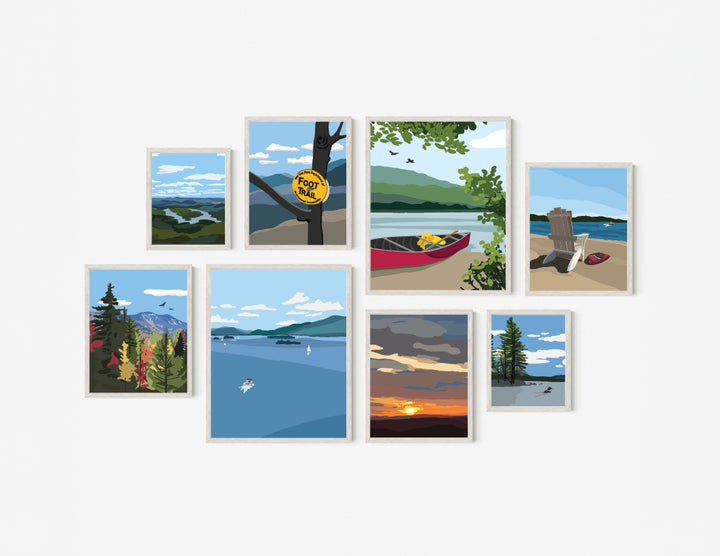 Set of eight framed illustrated Adirondack themed art prints featuring various outdoor scenes including a canoe on a lake, an Adirondack chair on a beach, a high peaks image in fall, lake placid from the top of whiteface, a foot trail marker on a tree, a sunset and two lake prints, one with a loon and one of lake George.
