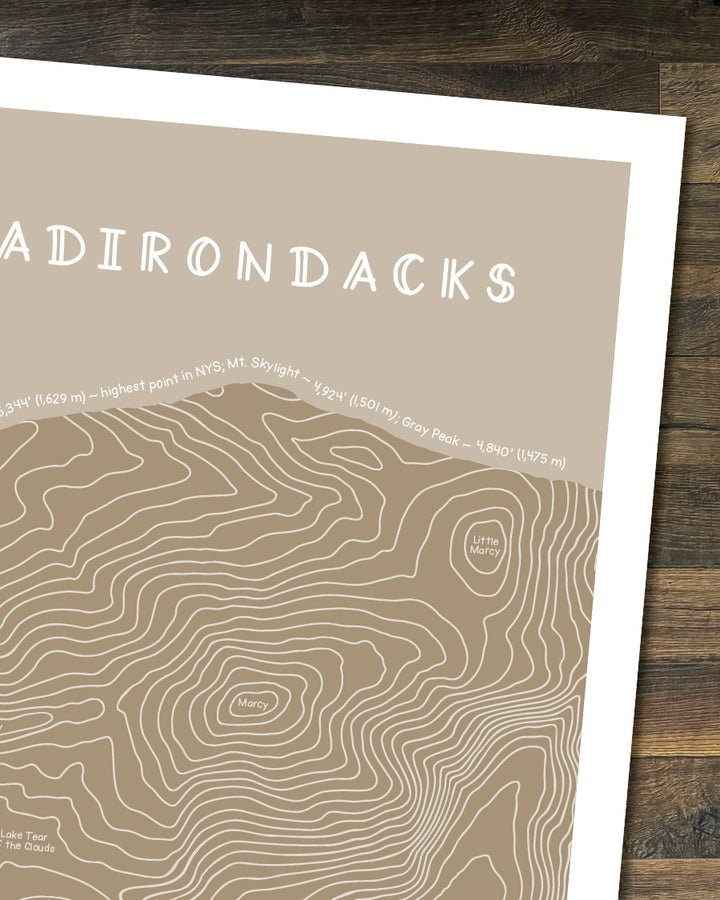 Cropped topographic map print in tan of the Adirondacks with a brown frame on a white background