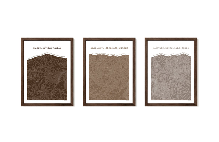 Walnut framed set of three topographic map art prints of Mount Marcy, Skylight &amp; Gray, Algonquin, Iroquois &amp; Wright Peaks, Haystack, Basin and Saddleback peaks in brown line patterns on a white background